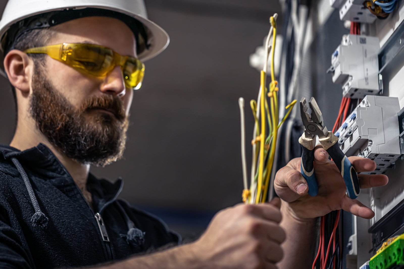 male electrician works switchboard with electrical connecting cable 1 scaled